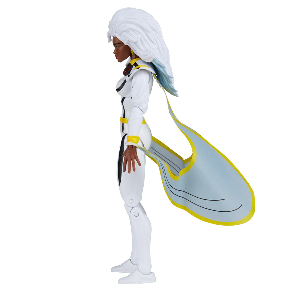 
                  
                    A 6-inch Marvel Legends Series X-Men Storm action figure in a classic white costume, accompanied by alternate hands with crackling electrical energy FX accessories, all contained in a '90s video cassette-inspired packaging.
                  
                