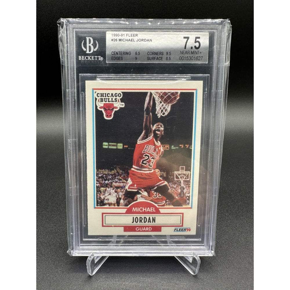 1990-91 Fleer Basketball #26 card featuring Michael Jordan mid-action on the court, in white, red, and black Chicago Bulls uniform. The card has a BGS grading of 7.5, placed in a protective transparent sleeve.